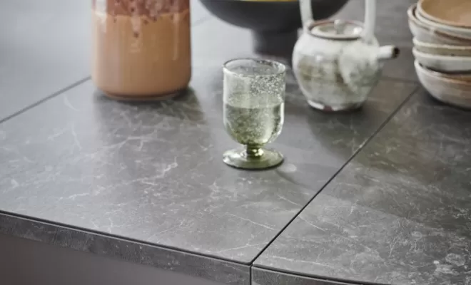 Table rondo ouverte avec plateau en céramique nero marbré et pieds en acier laqué époxy noir